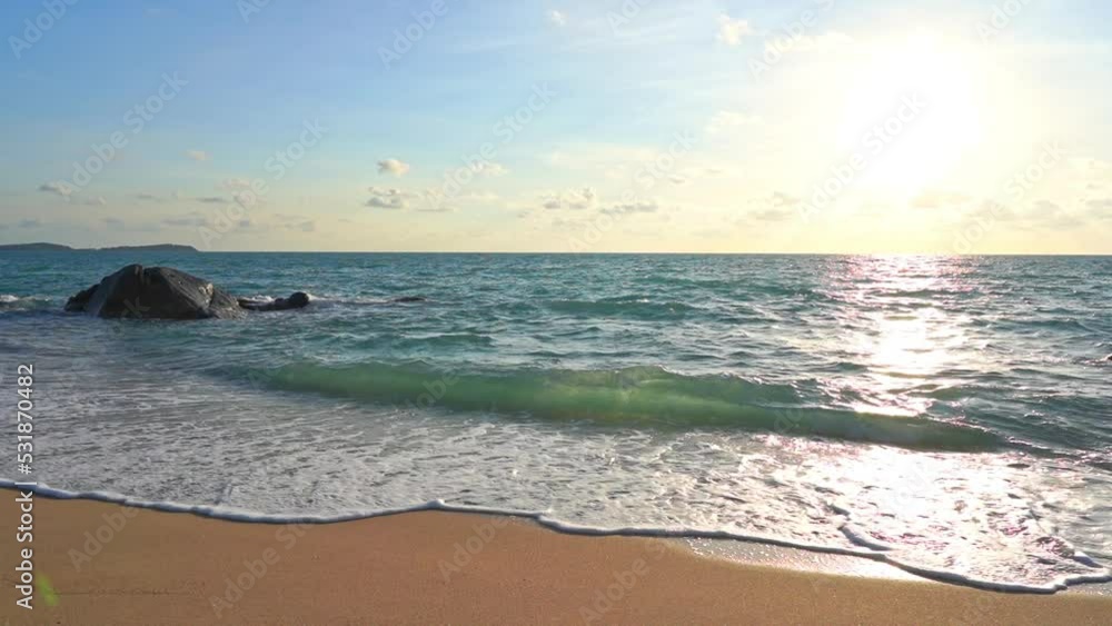 Waves roll in on a tropical beach as the sun sinks in the western sky. Waves roll in on a tropical beach as the sun sinks in the western sky.