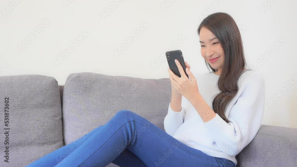 An attractive young woman intensely focuses on and reacts to her smartphone screen. An attractive young woman intensely focuses on and reacts to her smartphone screen.