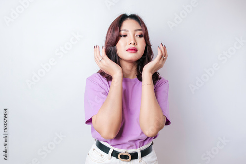 Portrait of young Asian woman isolated by white background feeling frustrated with helpless face expression.
