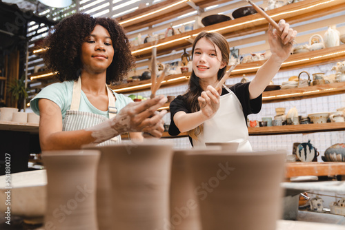 Creative afro American young woman artist molding clay on pottery wheel, Workshop in ceramic studio, clay making of a ceramic pot on the pottery wheel, hobby and leisure with pleasure concept