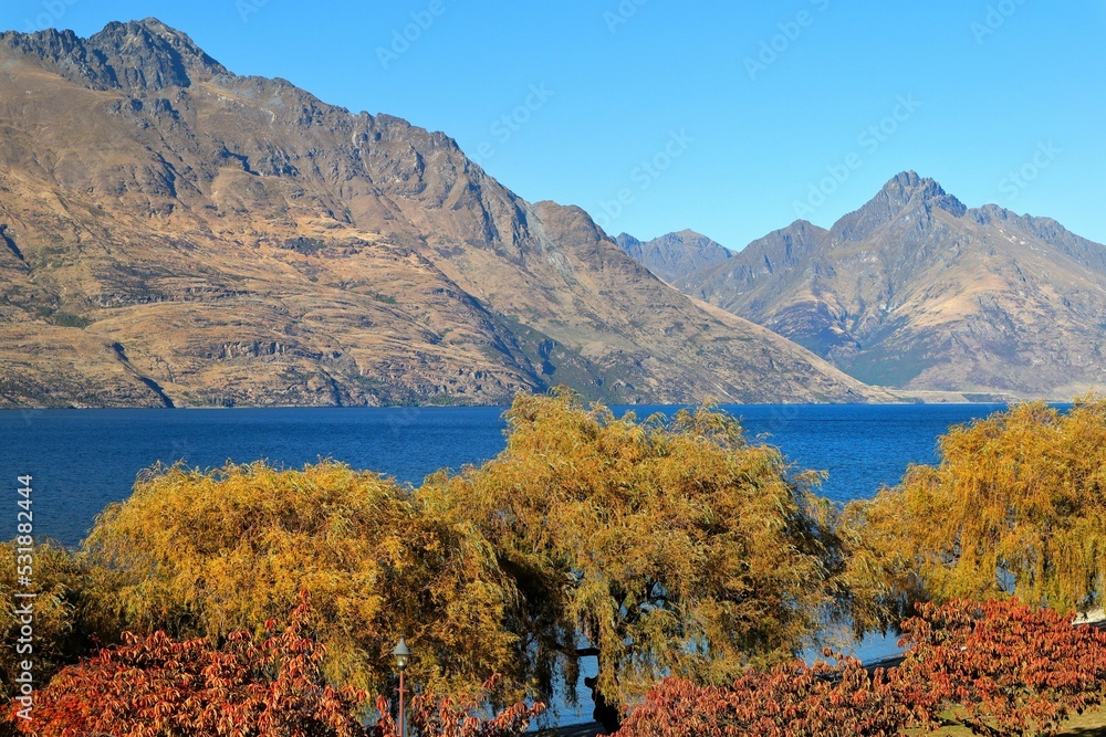 Fototapeta premium Beautiful shot of a lake surrounded by mountains against a blue sky in Queenstown