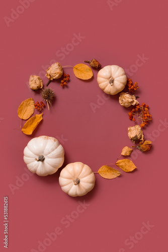 Autumn flat lay wreath of pumpkin, leaves and flowers with berries top view. Vertical format with copy space