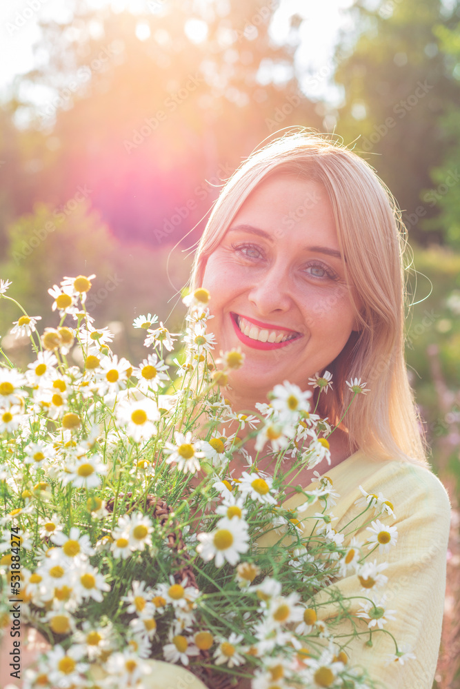 A girl in a yellow dress with a basket full of daisies in her hands A girl in a yellow dress with a basket full of daisies in her hands