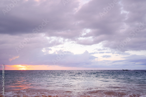 Seascape with sunset on the ocean shore. Beautiful cloudy sky.