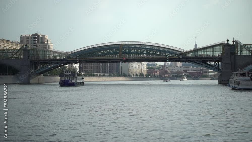 Metal and glass bridge or river. Russia, Moscow. 25 juli 2022. River tram sails along the Moskva River with passengers, river walk on a closed boat. High quality 4k footage Metal and glass bridge or river. Russia, Moscow. 25 juli 2022. River tram sails along the Moskva River with passengers, river walk on a closed boat. High quality 4k footage