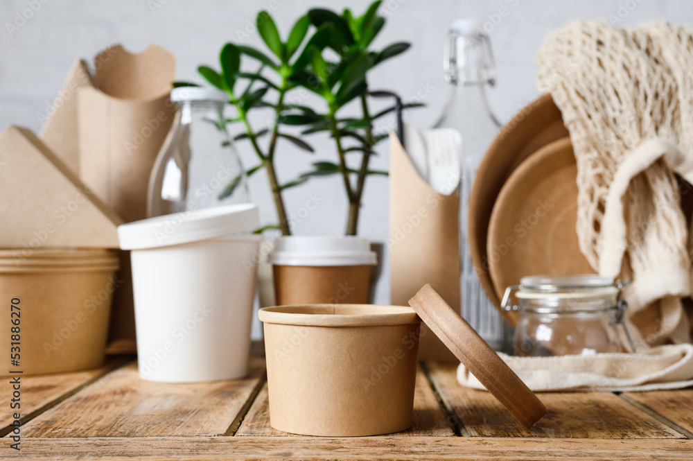 Round paper container for food on the background of paper utensils. The concept of zero waste. Round paper container for food on the background of paper utensils. The concept of zero waste.