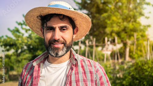 Portrait modern bearded farmer man looking at camera smile and stands in far,