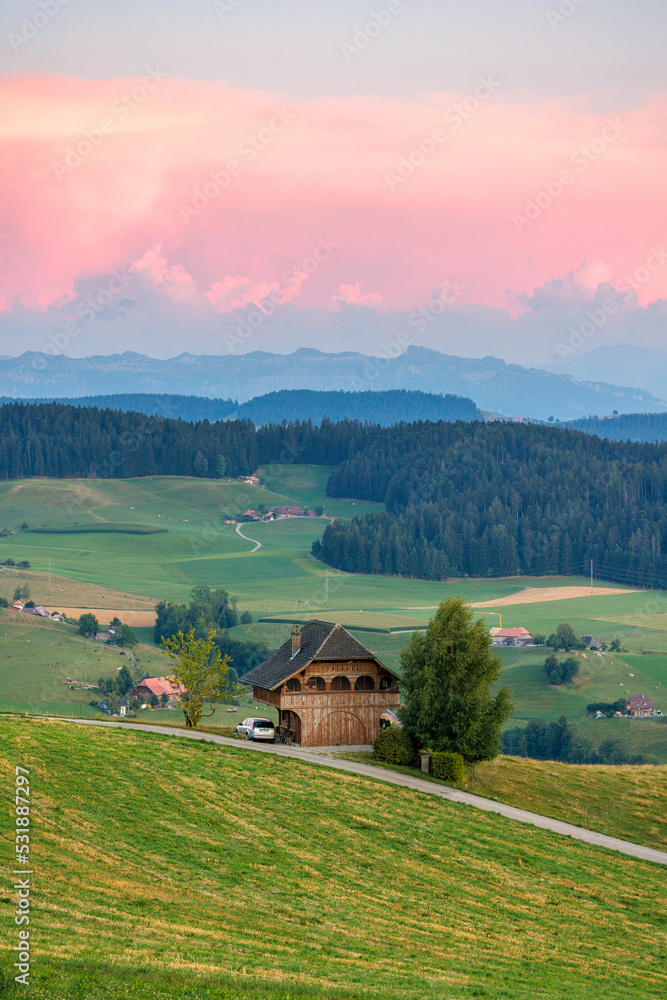 classical Emmental farmhouse at a summer sunset