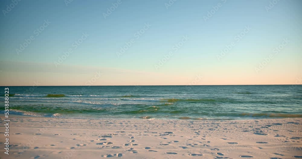 Shots of the ocean on a warm, sunny evening with footprints in the sand Shots of the ocean on a warm, sunny evening with footprints in the sand