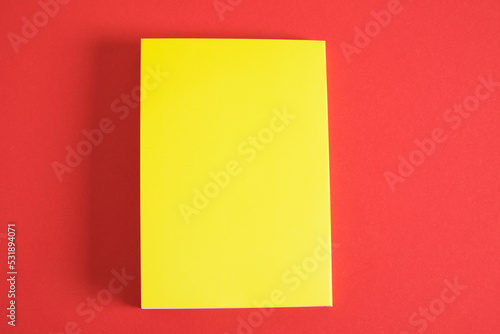 Design concept - Top view of yellow notebook and pen collection isolated on red background for mockup