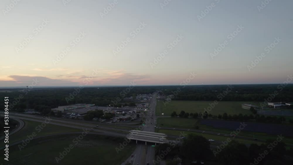 At twilight, a drone captured a small Ohio town near a highway where a car was speeding up and down. At twilight, a drone captured a small Ohio town near a highway where a car was speeding up and down.