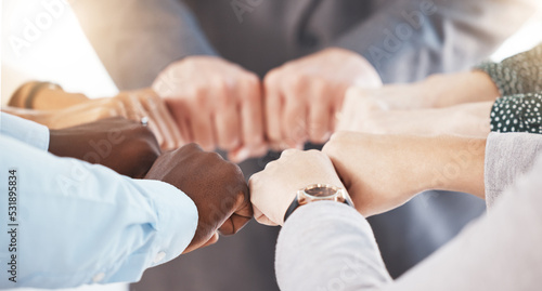 Hand  collaboration and motivation with the hands of a business team together in a huddle or circle. Teamwork  goal and target with an employee group joining their fists in trust  solidarity or unity