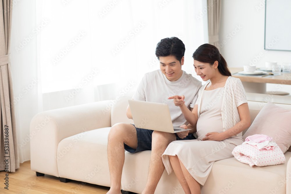 Young pregnant woman with husband shopping online Young pregnant woman with husband shopping online
