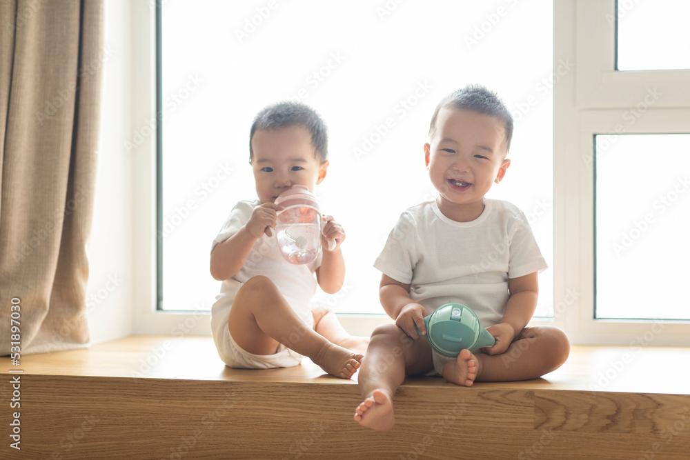Cute twin babies drinking water from baby bottles Stock Photo Adobe Stock