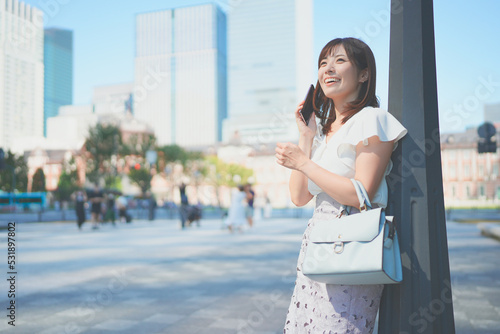 Tableau sur toile 東京駅でスマートフォンを操作しながら待ち合わせをする若い女性