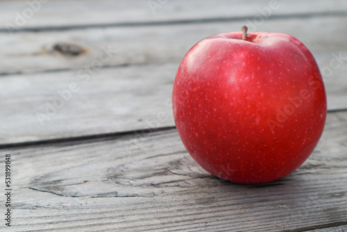 Red ripe apple on a rustic gray wooden boards. Copy space © Trik