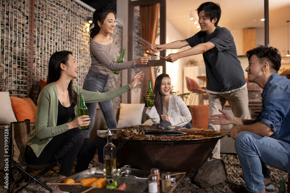 Happy young friends barbecuing outdoors Happy young friends barbecuing outdoors