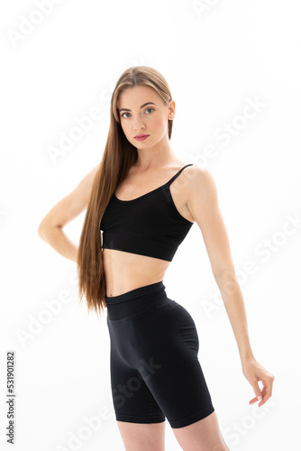 Slim sporty fitness young woman gymnast in sportswear training performs exercises on a white background © Andrei Pozharskiy
