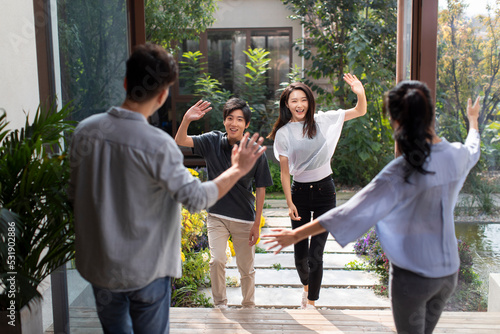 Young couple welcoming guests for party photo