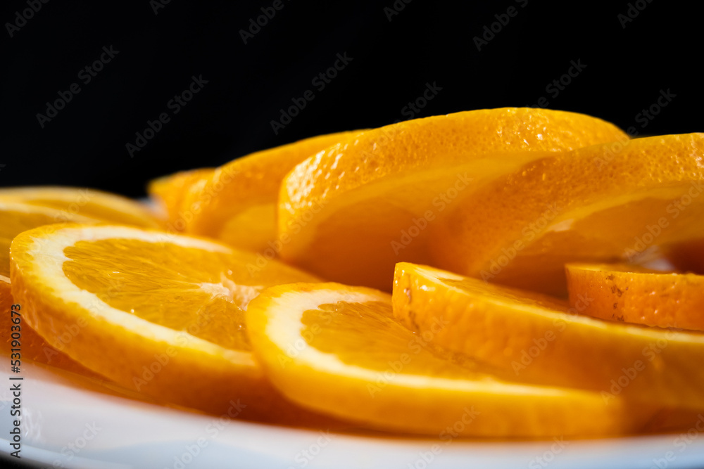 orange slices on a white plate. dark background orange slices on a white plate. dark background