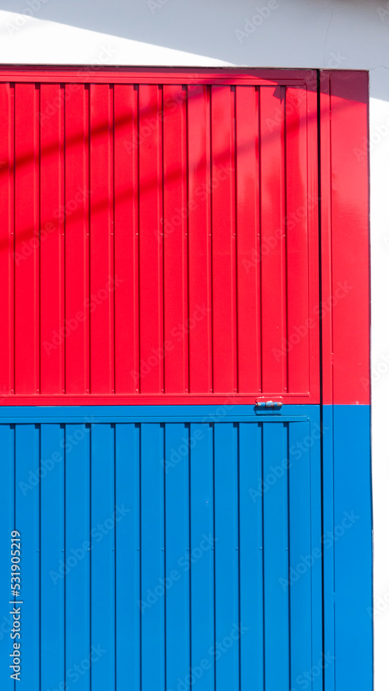 Puerta metálica roja y azul en nave industrial Puerta metálica roja y azul en nave industrial