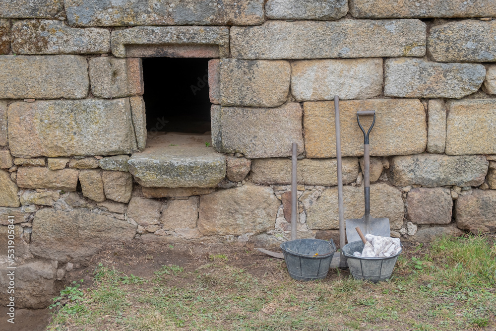 tools next to an ancient granite stone wall in an archaeological excavation tools next to an ancient granite stone wall in an archaeological excavation