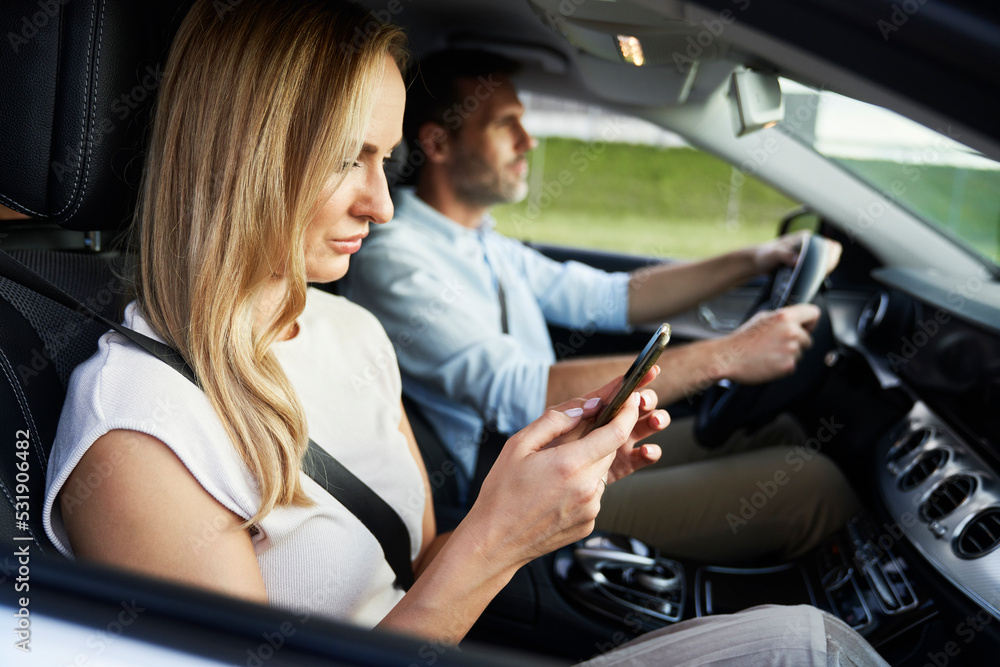 Fototapeta premium Caucasian of middle age woman using mobile phone during a car trip