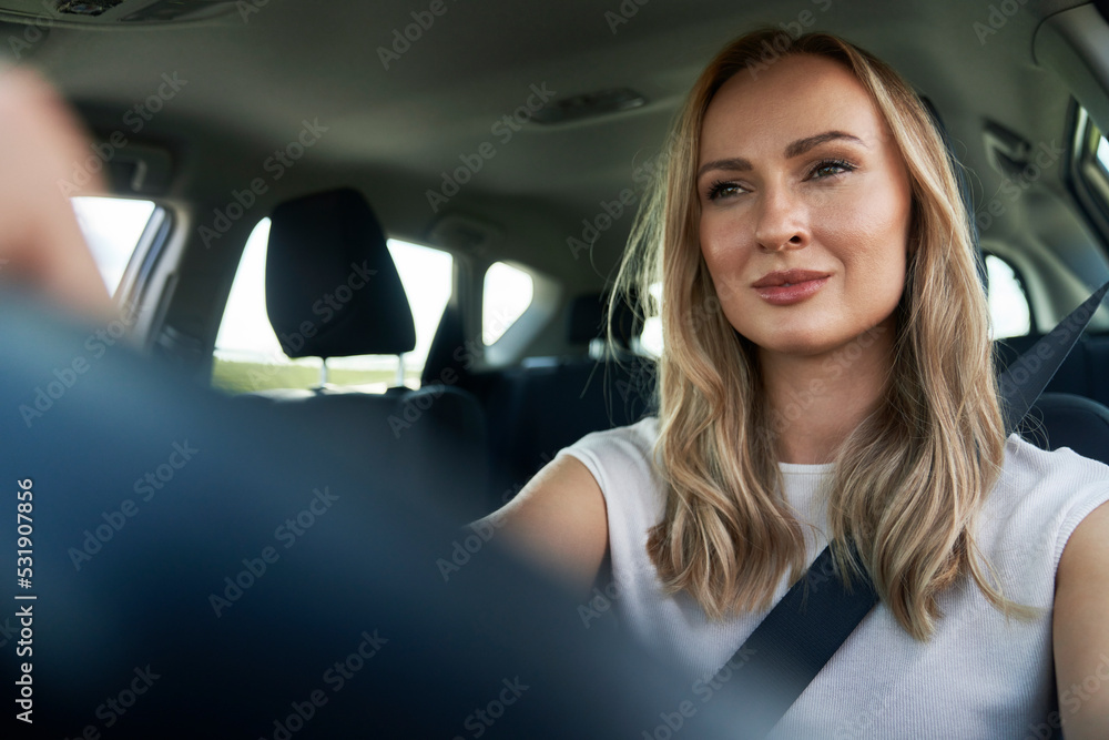 Caucasian adult blonde woman driving a car