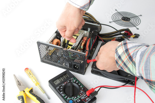 repair of a disassembled Computer Power Supply Unit, tester measurement, on a white background