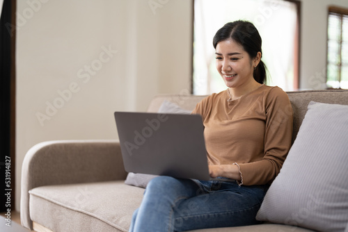 Young asian woman having conversation chatting while using laptop at house. Work at home, Video conference, Online meeting video call, Virtual meetings, Remote learning and E-learning
