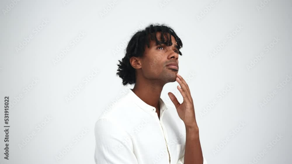 Handsome African man with dreadlocks thinking in the white studio Handsome African man with dreadlocks thinking in the white studio