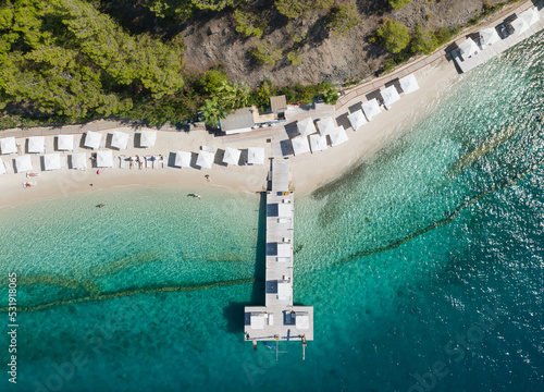 Fototapeta Naklejka Na Ścianę i Meble -  Turquoise Sea and White Umbrellas Drone Photo, Gocek Beach Fethiye, Mugla Turkey