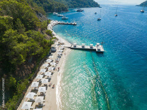 Fototapeta Naklejka Na Ścianę i Meble -  Turquoise Sea and White Umbrellas Drone Photo, Gocek Beach Fethiye, Mugla Turkey