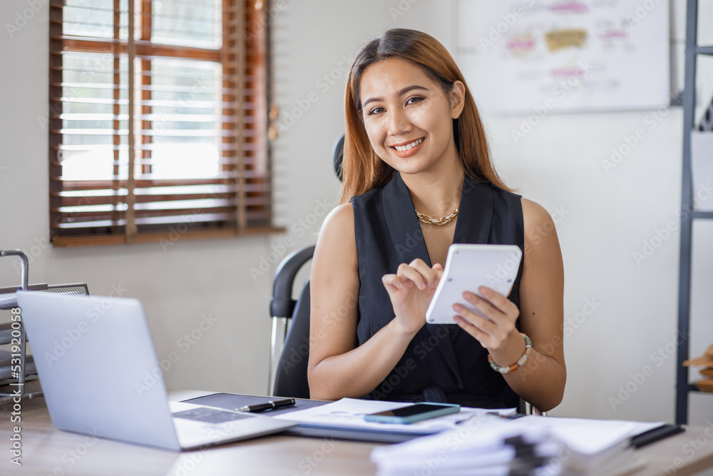 Obraz premium Business Asian woman Accounting using calculating income-expenditure and analyzing real estate investment data report Financial and tax systems concept.