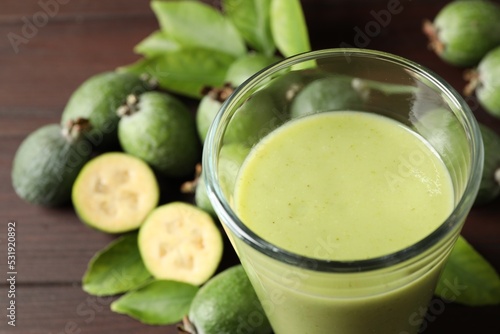 Fresh feijoa smoothie in glass on wooden table, closeup