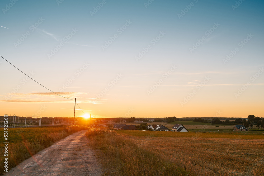 Gorgeous summer sunset landscape. Trees and fields in the rural area. Outdoors adventures in the countryside during summertime vacations.