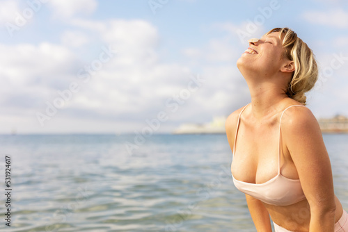Beautiful woman swimming in the ocean. Smiling blonde girl enjoy in sunny day