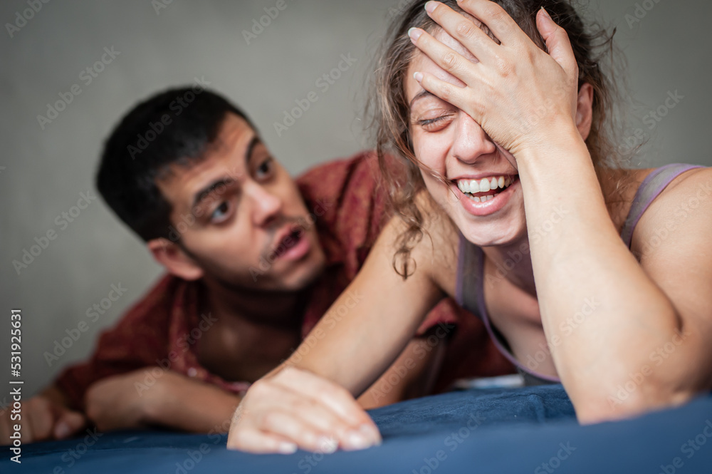 A man and a woman are arguing on the bed in the apartment. They are in a bad mood because they have love problems. A man and a woman are arguing on the bed in the apartment. They are in a bad mood because they have love problems.