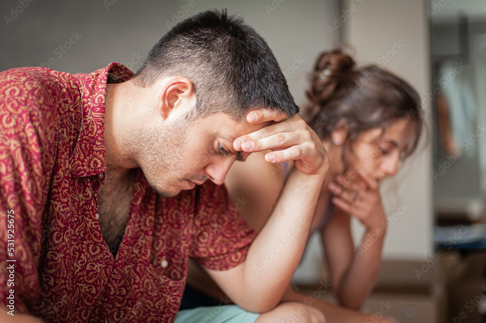 A man and a woman are arguing on the bed in the apartment. They are in a bad mood because they have love problems. A man and a woman are arguing on the bed in the apartment. They are in a bad mood because they have love problems.