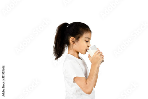 Side view of young Asian girl in white t-shirt drinking milk from a glass isolated on white background with clipping path.