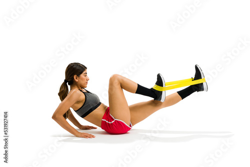 Profile of an attractive fit woman doing bicycle crunches using a resistance band