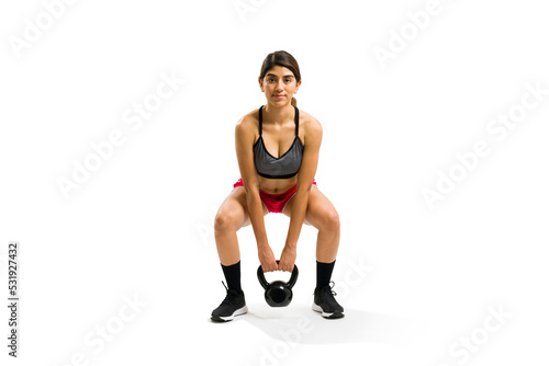 Gorgeous young woman doing weight lifting with a kettlebell