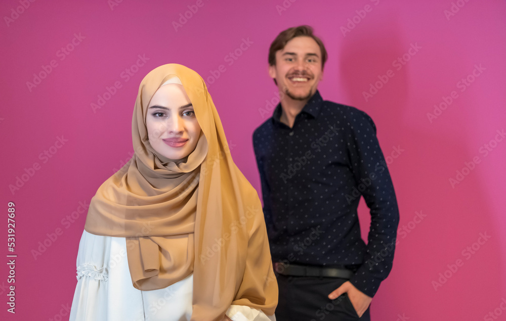 Portrait of happy young muslim couple standing isolated on pink background Portrait of happy young muslim couple standing isolated on pink background