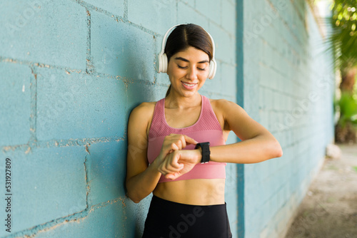 Fit beautiful woman counting her time after running or working out