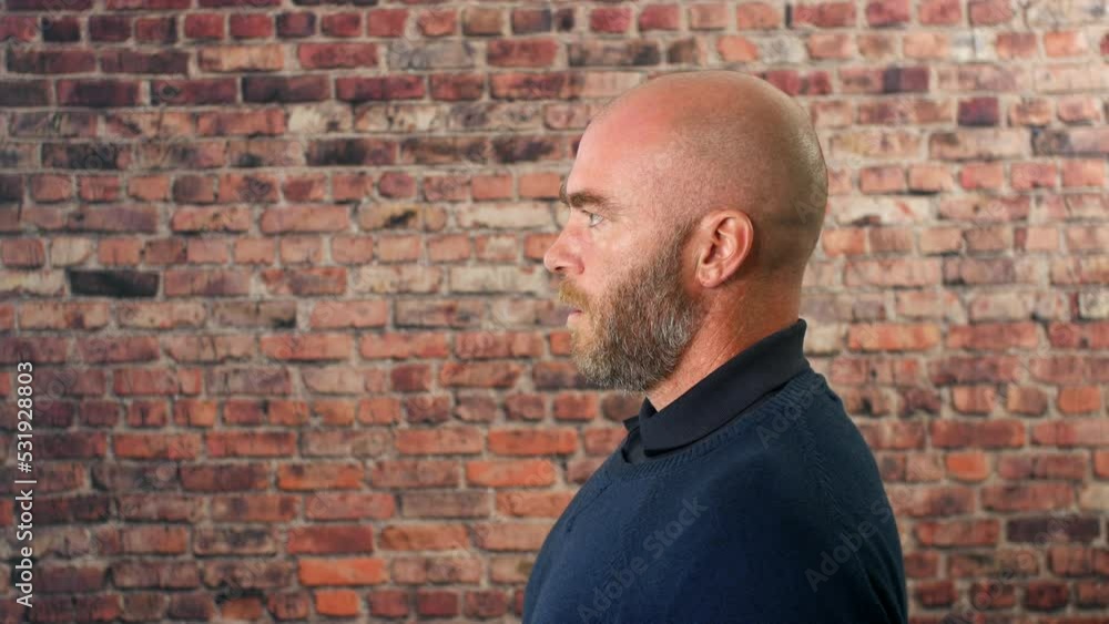 Side portrait of a man vaping indoors in front of a brick wall with cloud of smoke Side portrait of a man vaping indoors in front of a brick wall with cloud of smoke