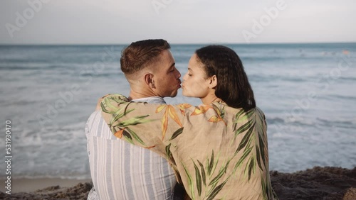 Rear view of affectionate young couple kissing on beach