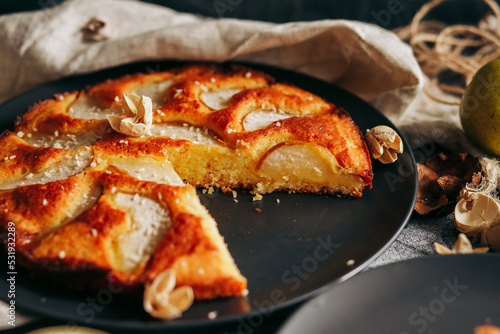 Cake with pear  honey and almonds. Delicious pie on a concrete table
