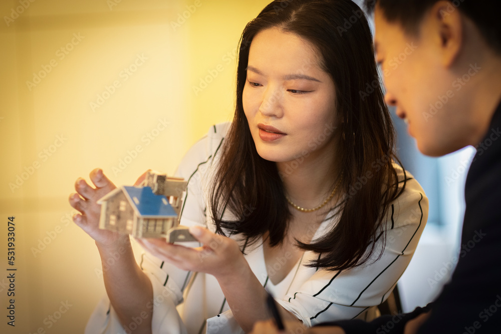 Architects examining tiny house model in meeting Architects examining tiny house model in meeting