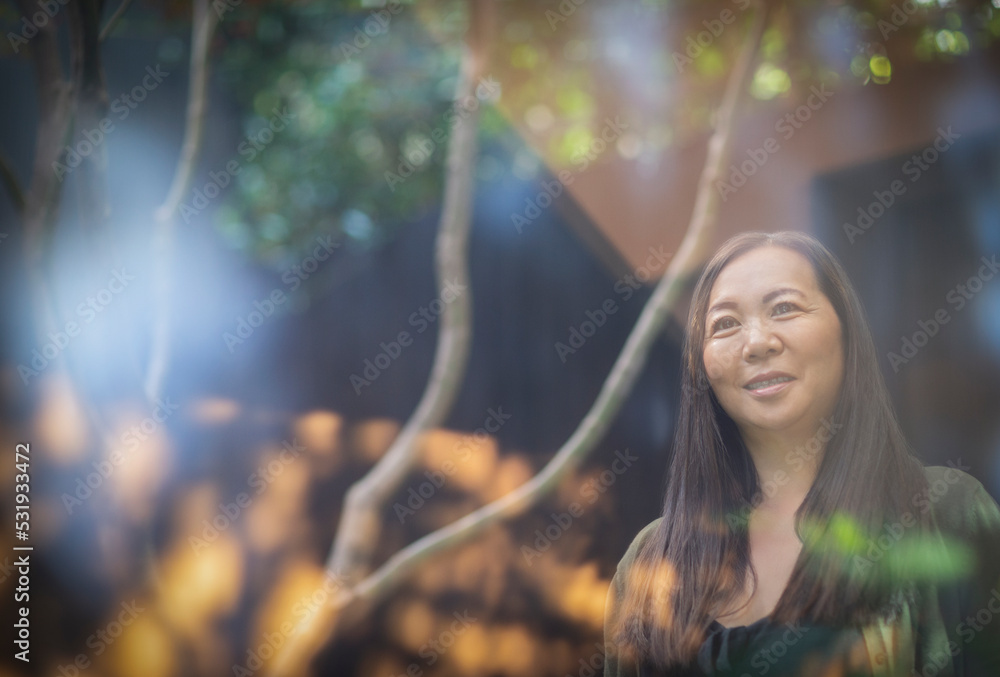 Smiling woman standing in sunny courtyard Smiling woman standing in sunny courtyard