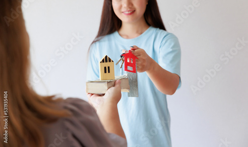 Smiling asian woman receives hand over keys for new house